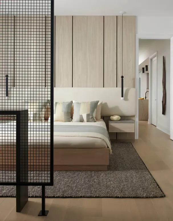 Bedroom with a wood panel headboard wall, a floating nightstand and a black metal grid screen
