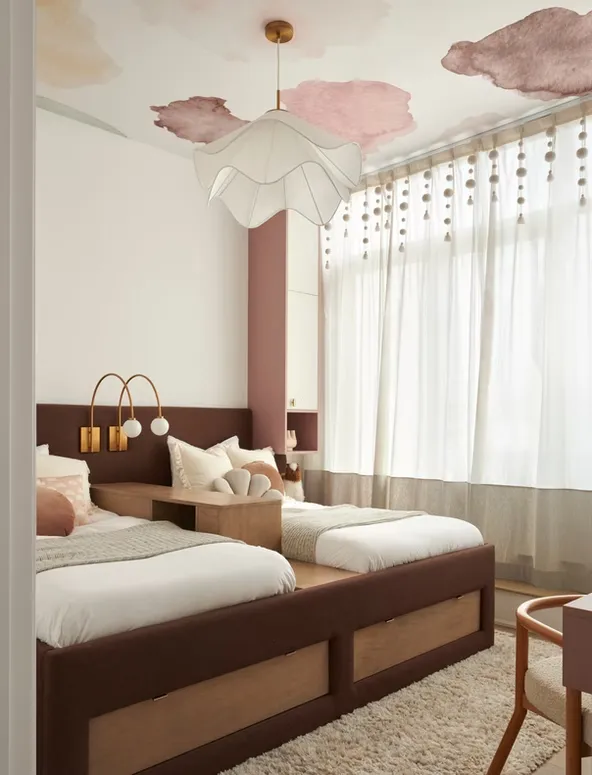 Kids bedroom with a built-in daybed with drawers, pink accents and a wall-mounted brass reading light