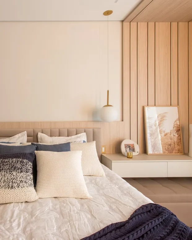 Bedroom with an oak slat wall panel, an upholstered headboard and a floating bedside shelf