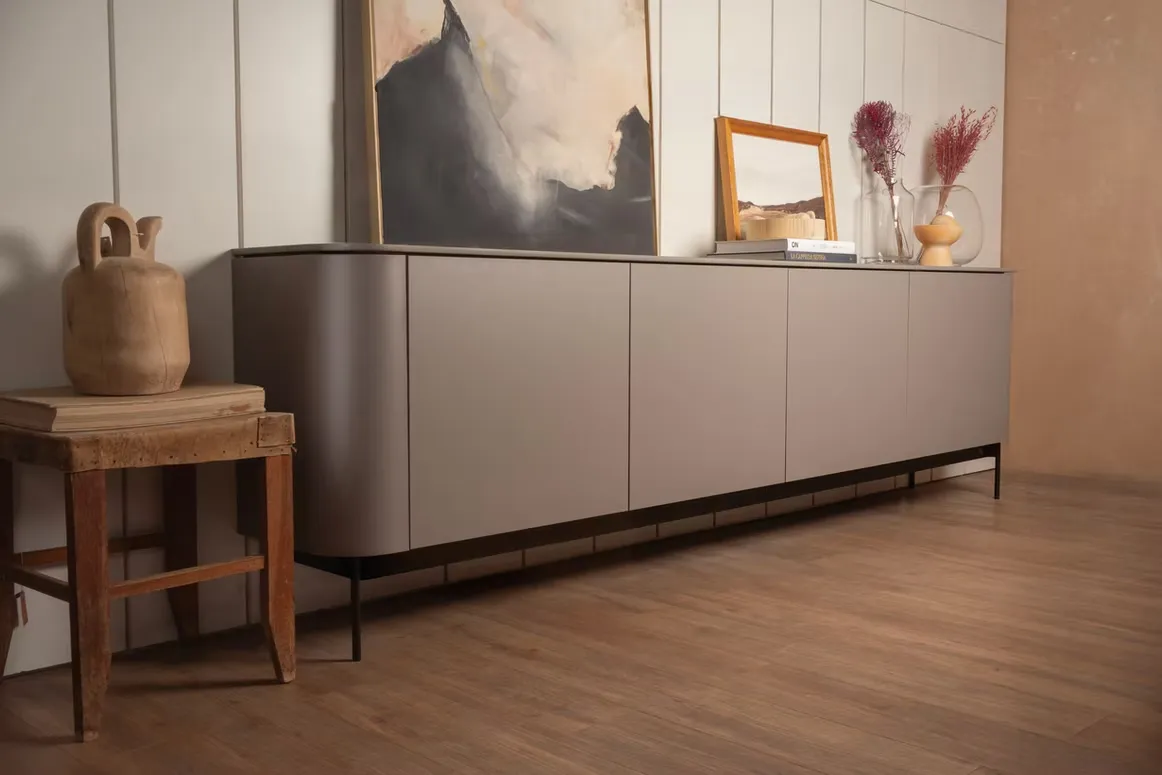 Curved-end taupe sideboard on slim black legs with wall panelling above