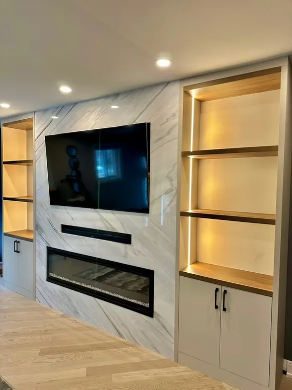 Marble-look fireplace wall with a recessed TV, lit open shelves and white lower cabinets