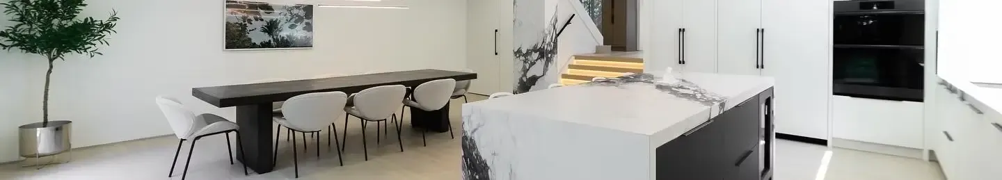 A VIVA Group kitchen with a marble island and a long dining table