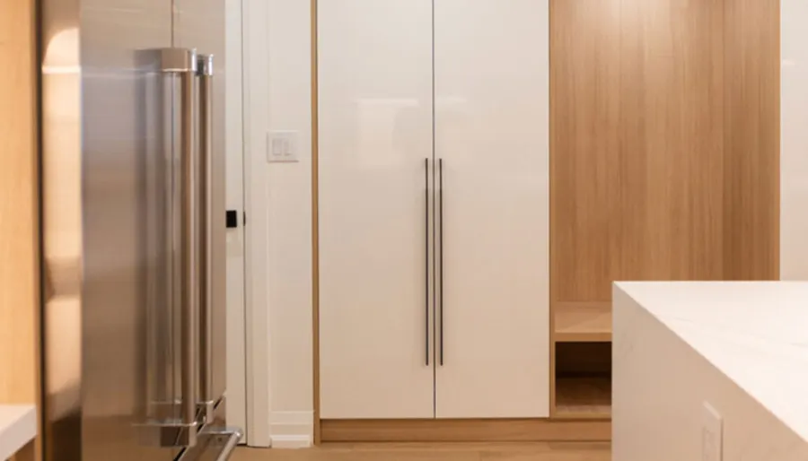 White and oak foyer cabinets with a bench nook by VIVA Cabinetry