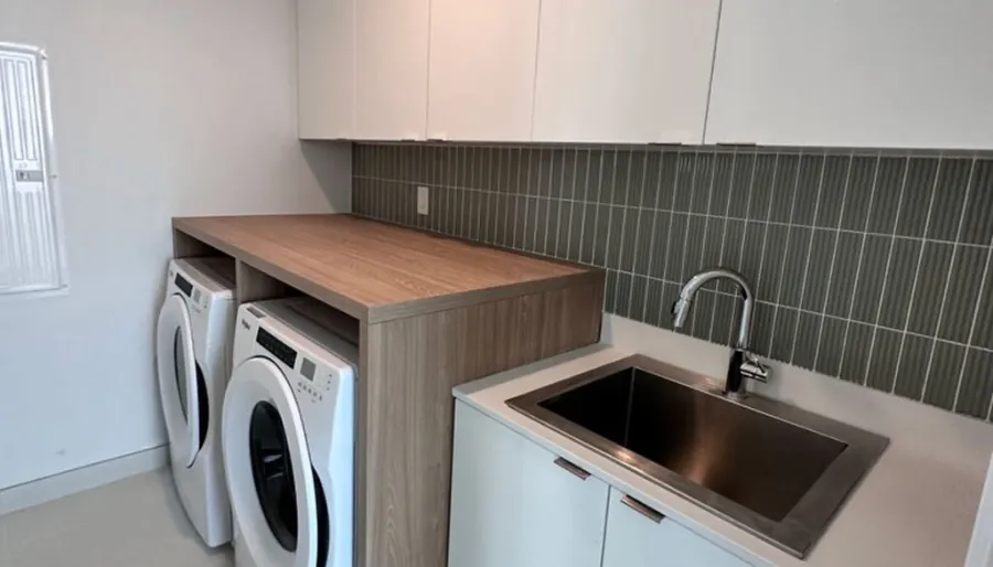 Laundry room cabinets with countertop over side-by-side washer and dryer by VIVA Cabinetry