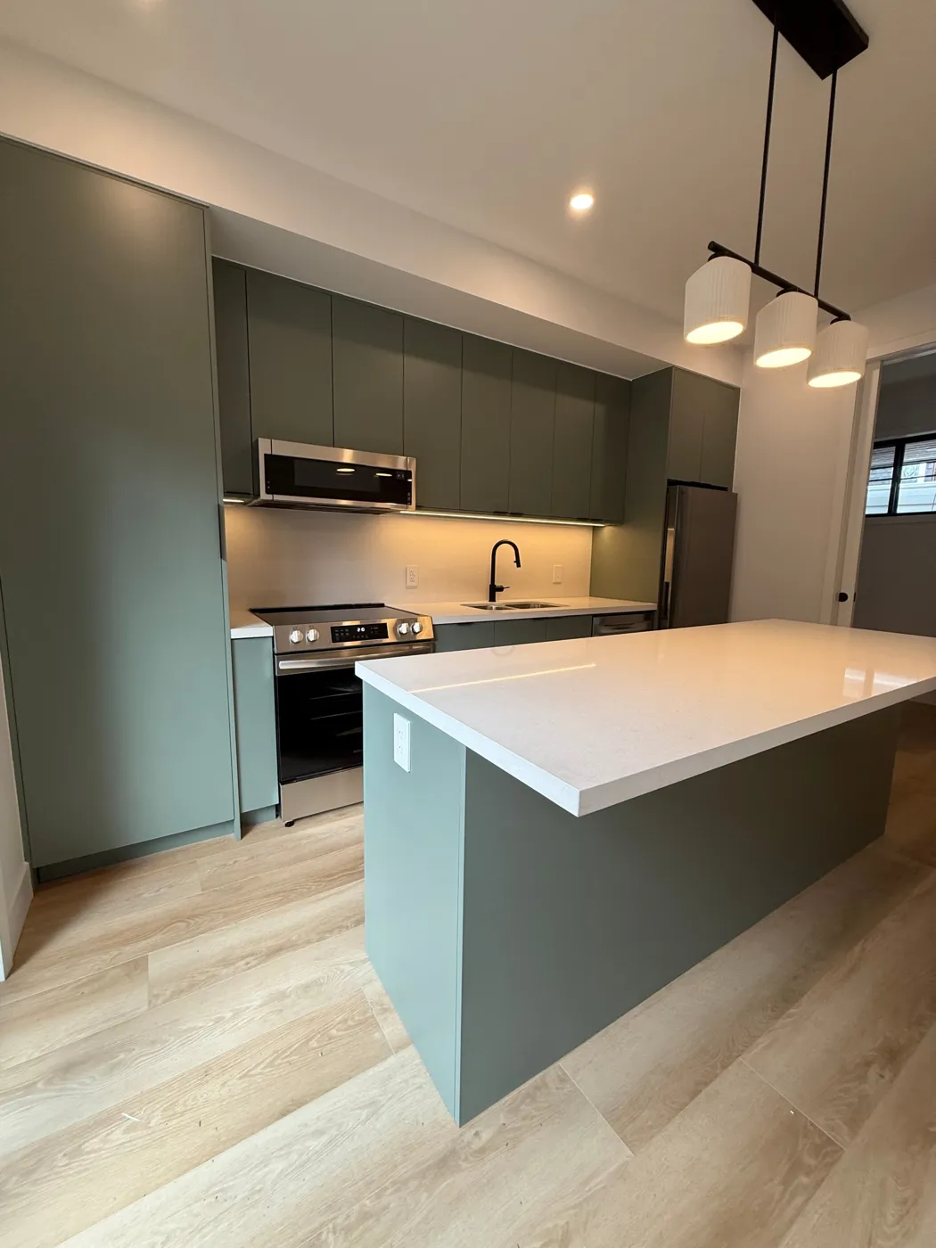 The same sage green kitchen, built and installed by VIVA Cabinetry